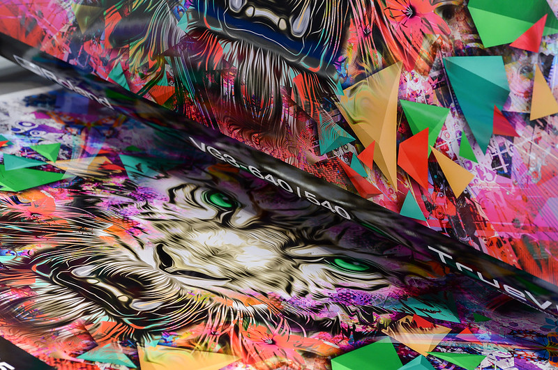oto of a roll of printed graphics displaying brightly coloured triangles and an illustration of a tiger face.